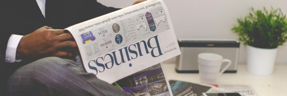 person sitting near table holding newspaper